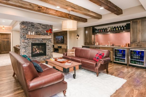 A stacked stone fireplace, ceiling beams, wet bar and casual furnishings make this basement living area a great space for entertaining or quite relaxation. 