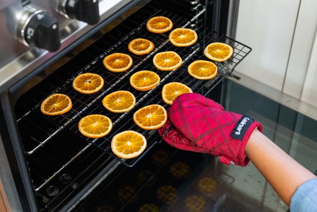 The next step in drying orange slices is to place the slices on a metal cooling rack and put them in the oven at 175 degrees F.