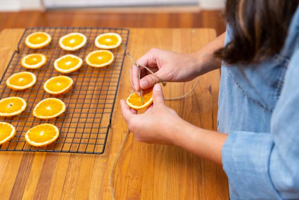 The next step in creating this dried orange slice garland is to thread the twine through the orange slices using a crochet needle.