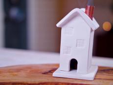 Small, handmade clay house with copper pipe used as incense burner