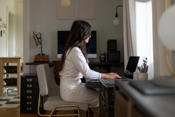A woman works in a modern, functional home office.