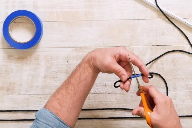 Using a tape measure, measure 20, 100-inch pieces of rope and cut with scissors. Tip: Wrap painter’s tape at each 100’’ mark and cut in half to prevent the cords from fraying. 