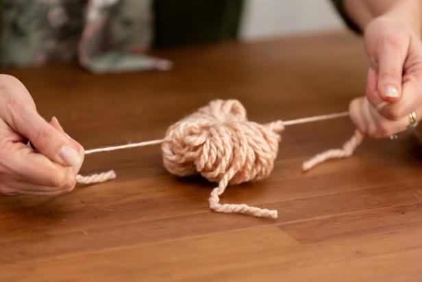 Lay the pom-pom in the center of the pre-cut piece and then tie a basic knot in the center.