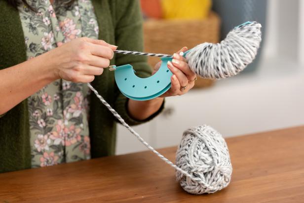 When one side of the pom-pom maker is very full, switch to wrapping on the other side, but do not cut the yarn. Use half the skein on one side, and half the skein on the other.