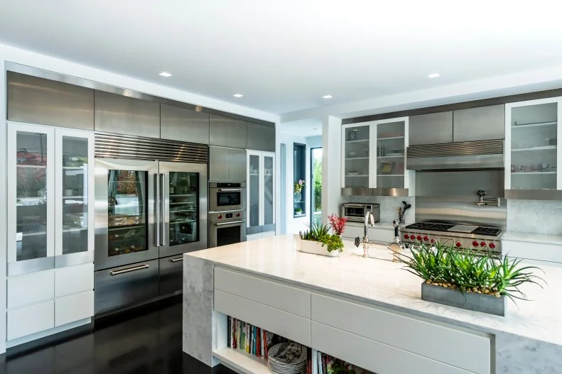 Steel walls and appliances surround an oversized kitchen island.