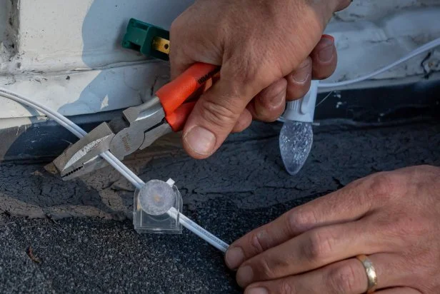 Pliers are used to cut bulk Christmas string lights to a custom length. The wire is made to be cut to a custom length and fitted with ends for perfectly sized string lights.