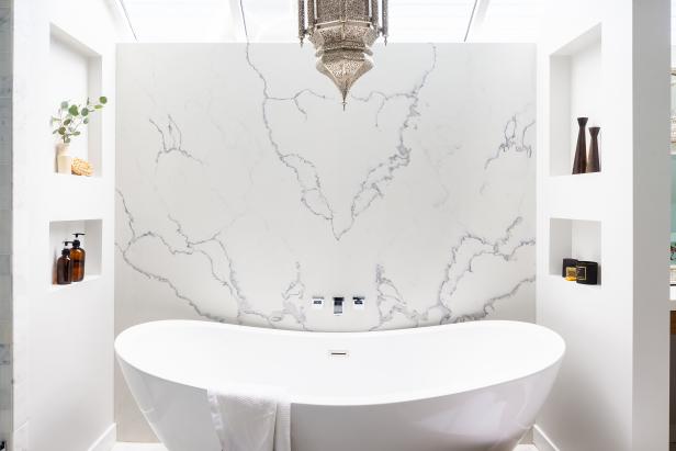The bathtub is the focal point of the master bathroom. A marble backdrop and walls featuring cutout shelving create a nook that feels like a sanctuary. “For me, self-care means getting small moments of time back,” Breegan says. For an interior designer, TV personality and mom, getting those moments back is not only vital, it requires planning. This bathroom is definitely designed with that in mind. The massive soaking tub is ideal for reclaiming moments as the day slips away.