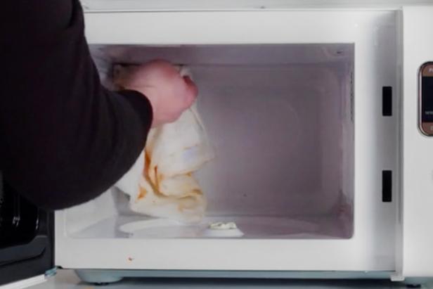 Use a cloth towel to wipe off the splatters and spots inside the microwave.