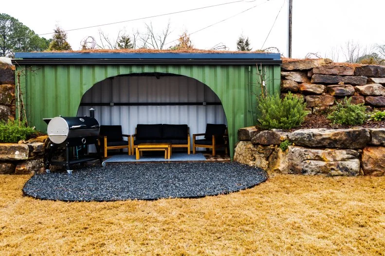 A cleverly repurposed shipping container with a grill and refrigerator serves as a community "burrow" or gathering place in the Micro Village.