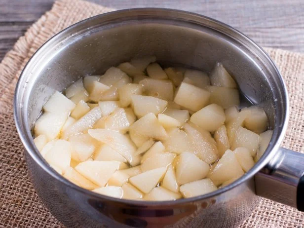 Pears cut into pieces sit in cook pot.