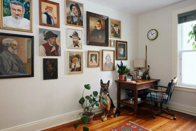 Gallery Wall With Paintings of Old Men Hang in Vintage Home Office