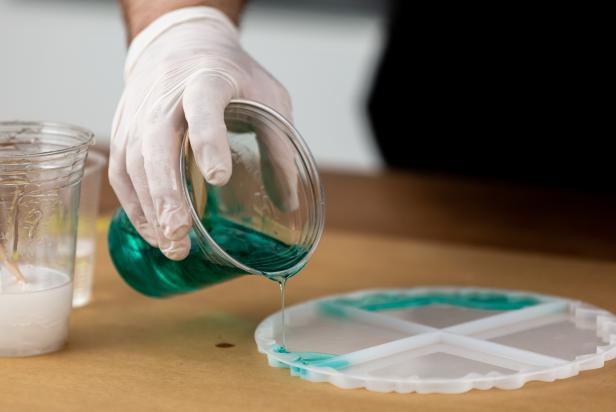 Pour a thin layer of the teal resin around the outside edge of your chosen mold.
