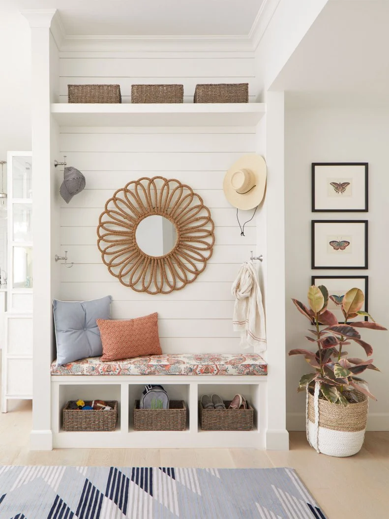 From the moment you step into the home, there’s an irresistible California-cool vibe. Shiplap-inspired paneling, light French oak floors, and a jute mirror by Jamie Young are a little beachy, while a graphic rug by Feizy brings modern flair. A built-in bench, baskets, and hooks create a dream mini mudroom. 