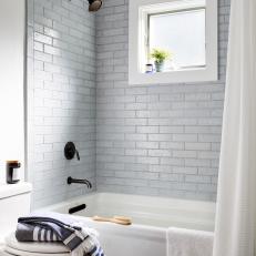 Bright Shower Features White Brick-Style Tile, an In-Shower Window and Modern Black Fixtures