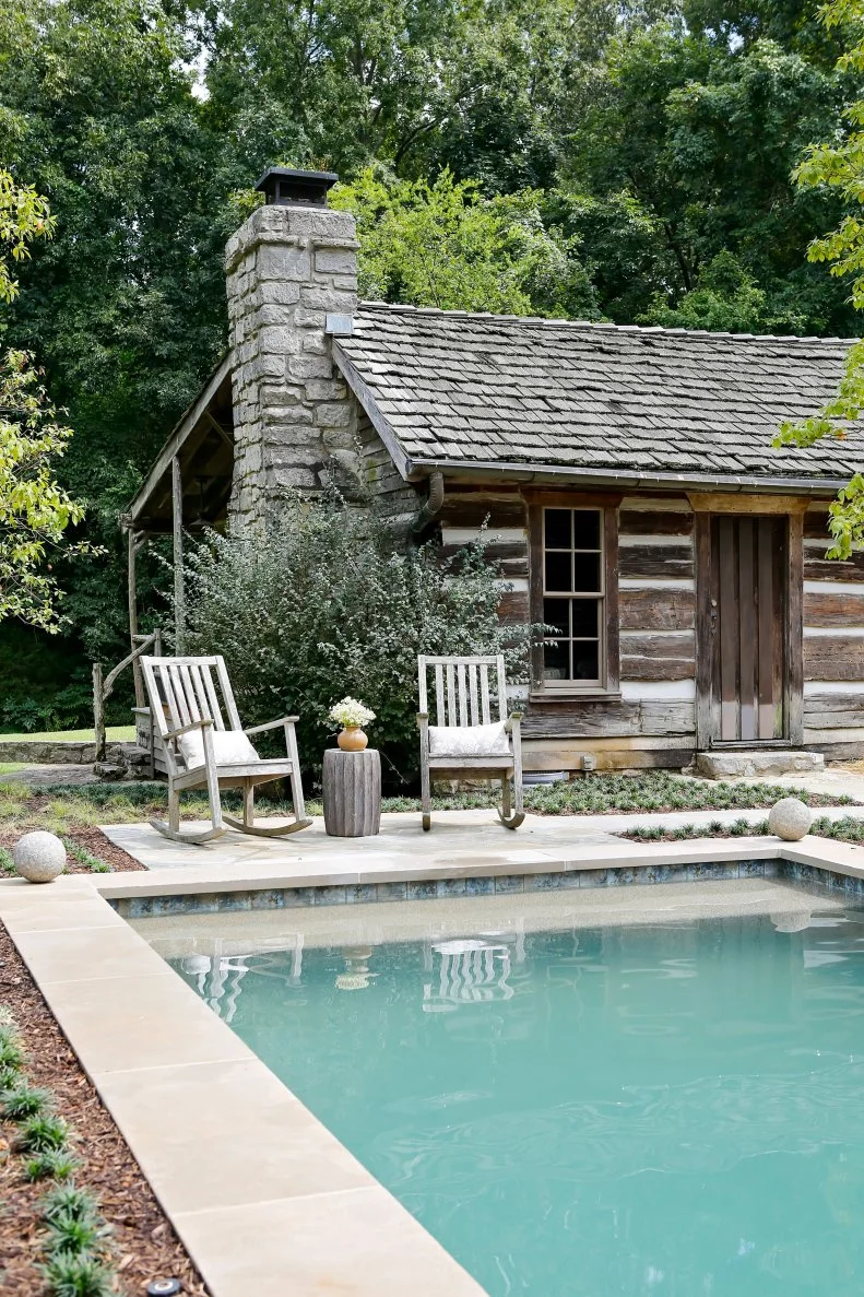 Rustic Log Cabin Guest Cottage With Stone Chimney Beside Large Pool