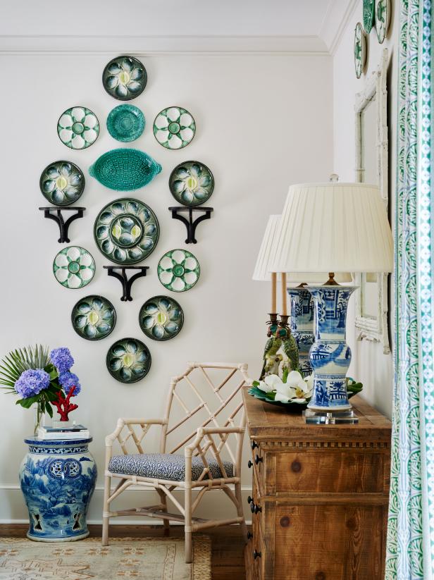 Teal and green porcelain dishes hang on a wall.