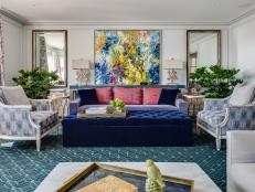 Velvet Ottoman on Green Rug in Living Room With Contemporary Art
