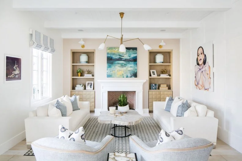 Neutral Living Room Features Built-In Bookshelves and a Fireplace