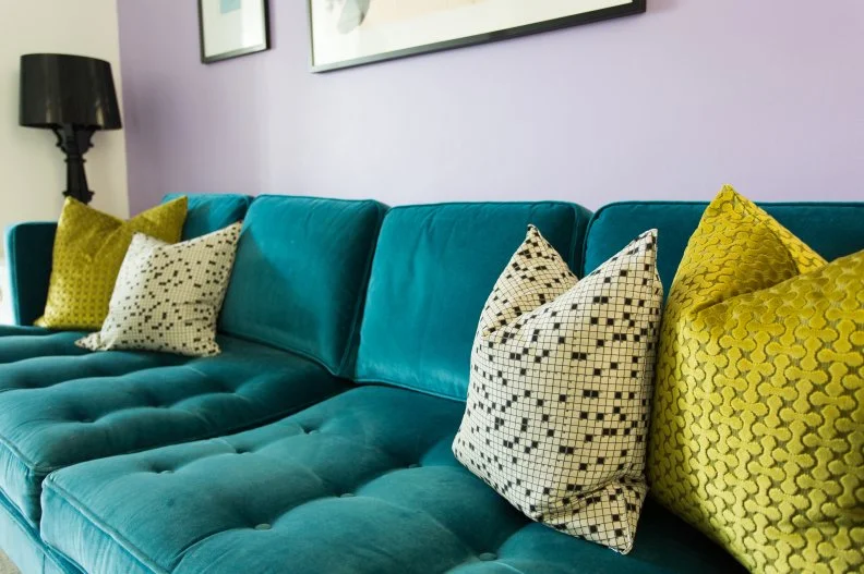 Living Room With Velvet Green Sofa, Pastel Color Accent Wall, Pillows