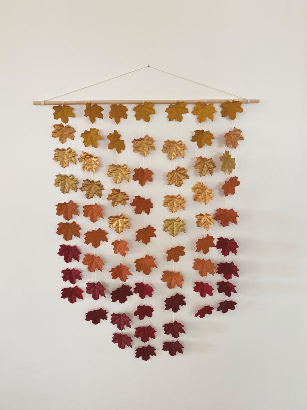Painted Faux Fall Leaves on Strands Hanging From Dowel Rod on Wall