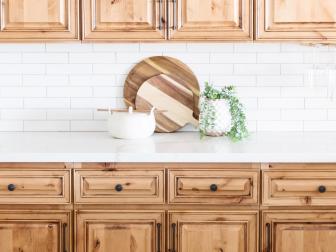 Warm Wooden Cabinets in Rustic Kitchen With White Brick Backsplash