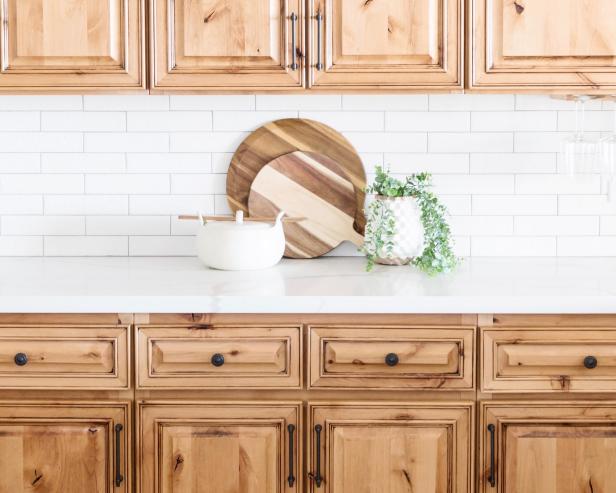 Warm Wooden Cabinets in Rustic Kitchen With White Brick Backsplash