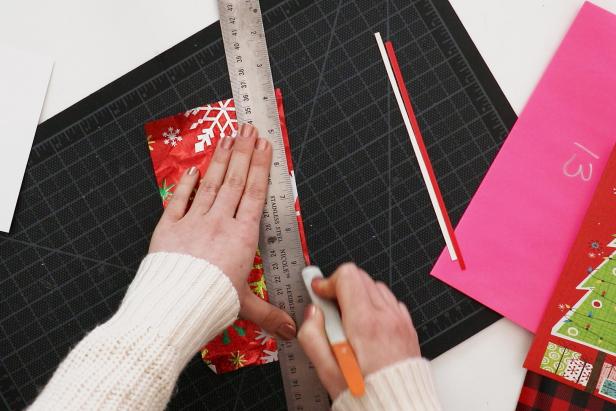 Cut down your old cards and wrapping paper into strips of varying widths. Use a glue stick to glue them onto the insert. Trim the excess.