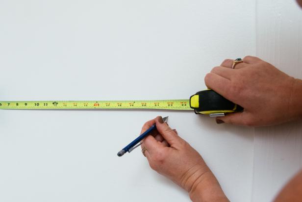Measure and mark the width of the wallpaper, minus two inches, from the corner of the wall you’ve chosen as your starting point.