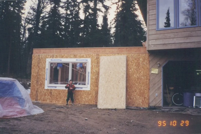 Kid Stands Outside Custom Alaska Cabin Being Built In Old Photo