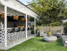An Outdoor Kitchen in a Lush Backyard Features Modern Accents 
