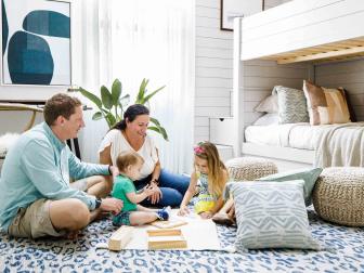 The large blue and white area rug and floor pillows provide plenty of room to relax and play as a family.