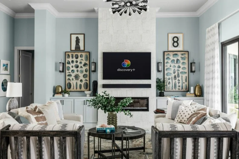 Pops of black help modernize this coastal living room while natural scientific drawings of sea life and shells add a sense of place and anchor the fireplace on each side.