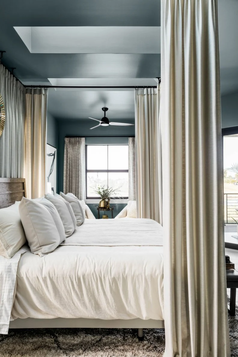 Using tones of white and gray on the bedding enhances the room’s peaceful feel and promotes rest and relaxation. 