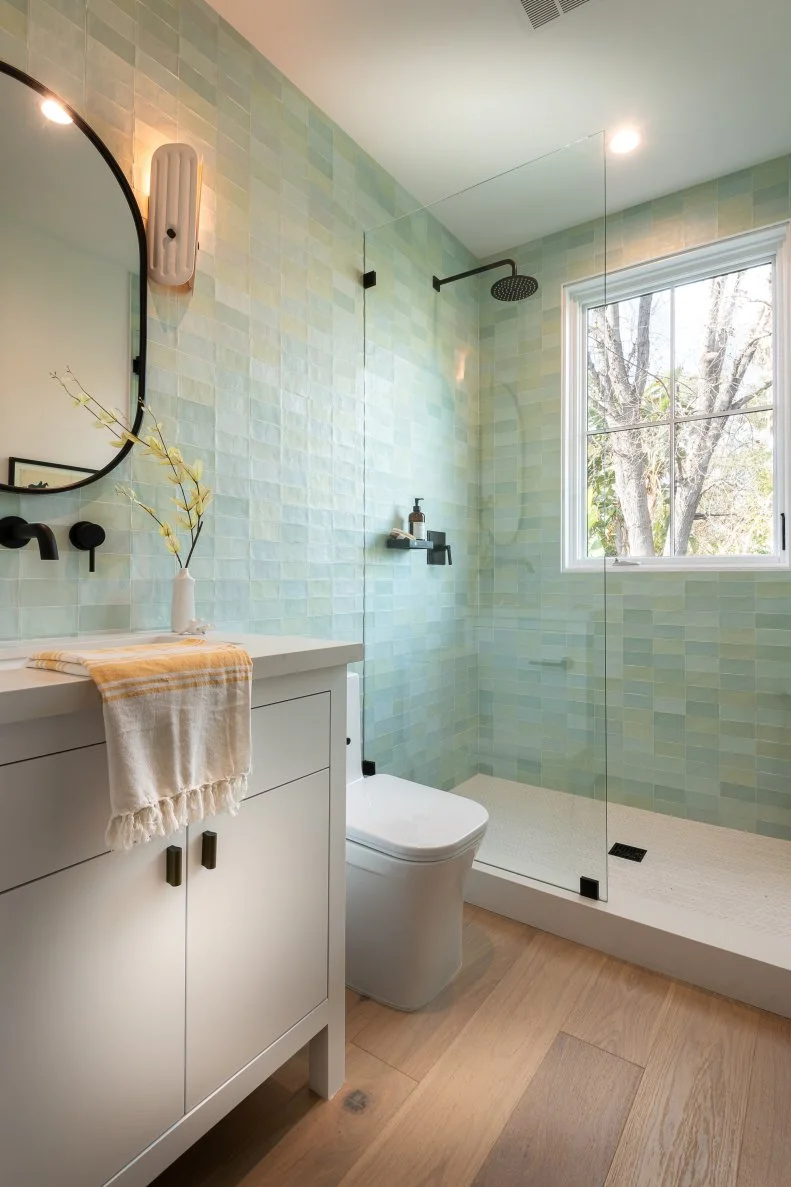 This guest bath features pale green subway tile.