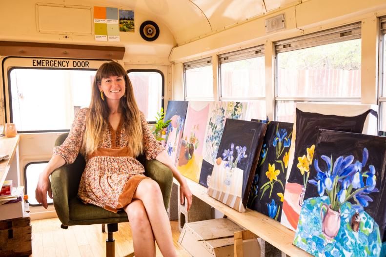 Woman Sits Inside Small School Bus Studio Smiling at Camera