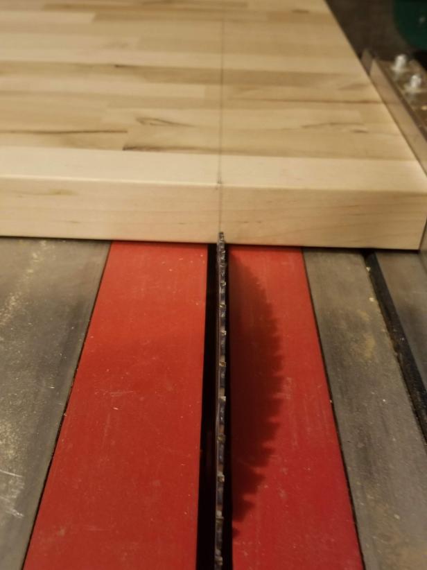 A table saw is used to cut a piece of butcher-block countertop.