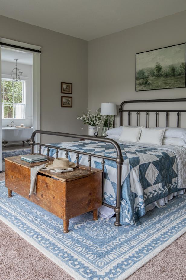 Rustic bedroom with blue and white accents and large wooden chest.