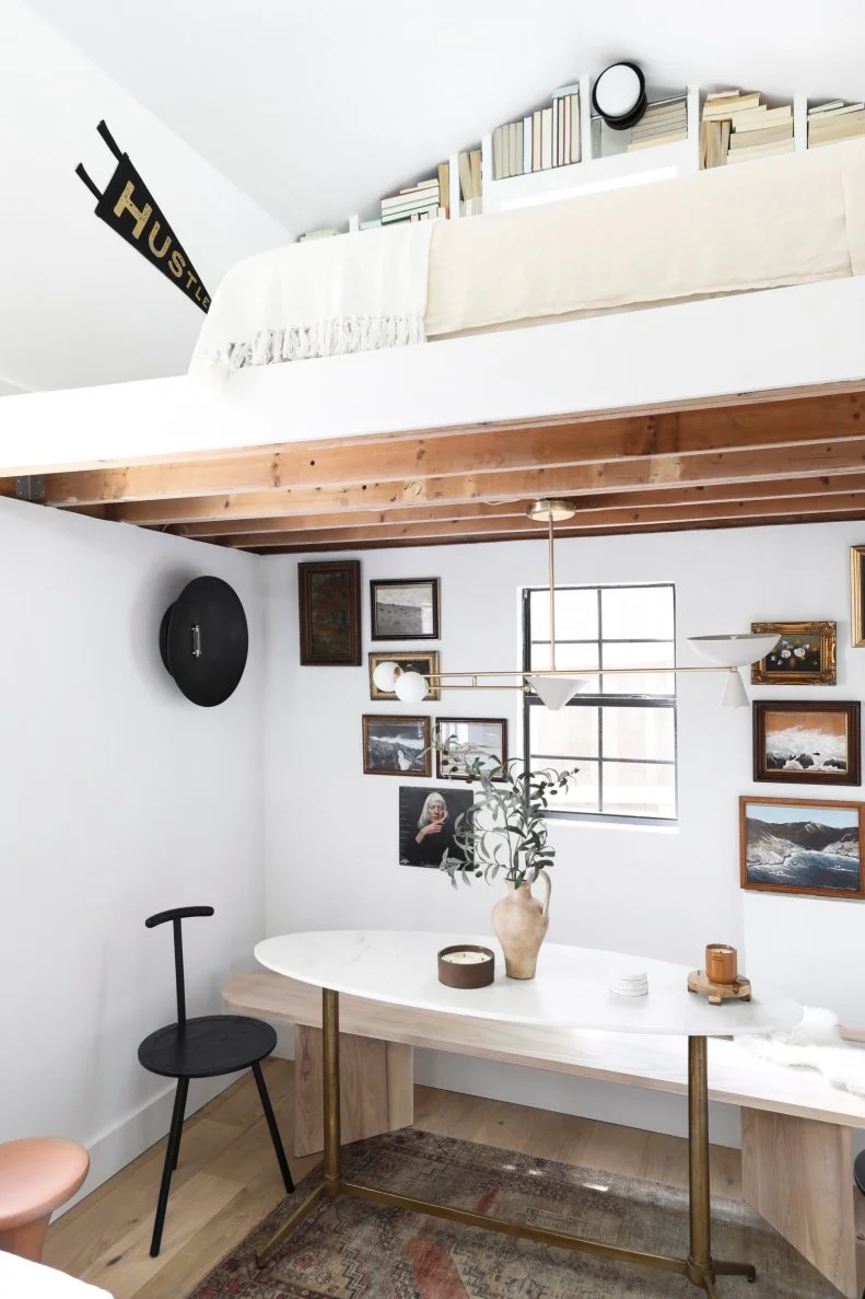 Neutral dining nook below lofted white sleeping space.