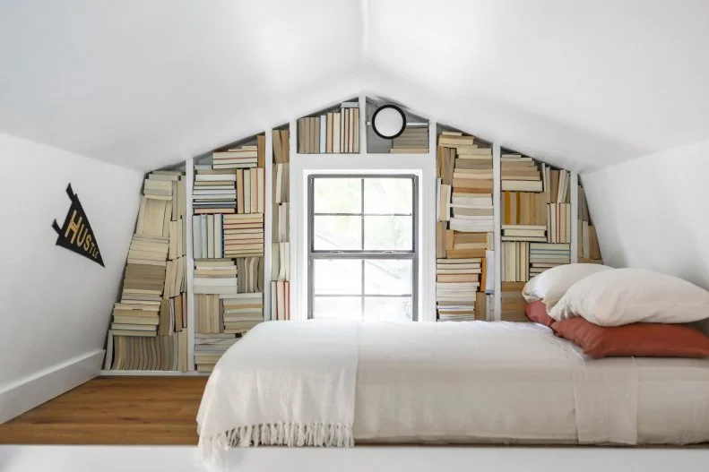 Under-roof white sleeping nook with books as decor.