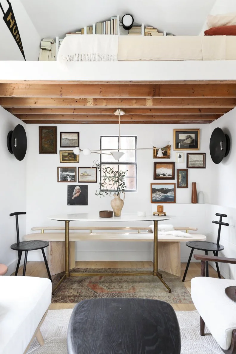 White nook with natural bench, white table and wooden beams.