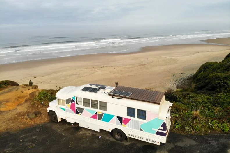 School Bus Home Parked in Desert, If Not Now When Slogan on Side