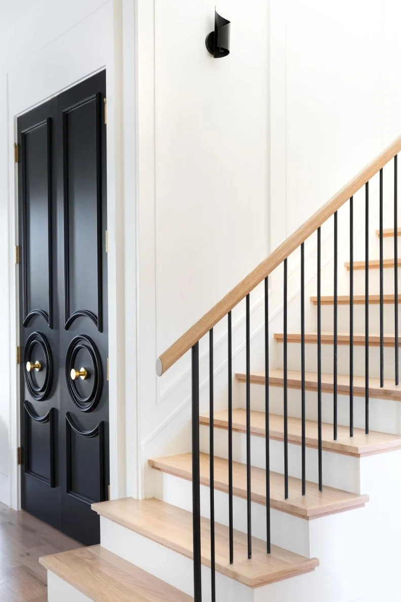 Wood Stairs With Modern Black Railing Beside Black Door Closet