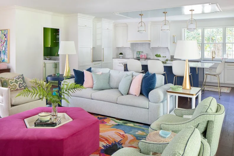 Living space with bold and colorful patterns and crisp white kitchen. 