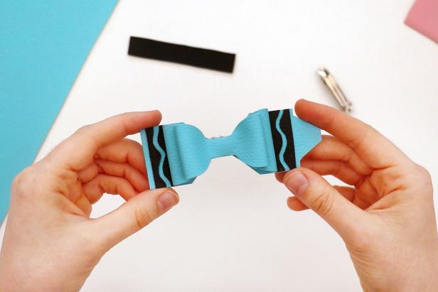 Use hot glue to glue the two bows on top of the crayon shape.