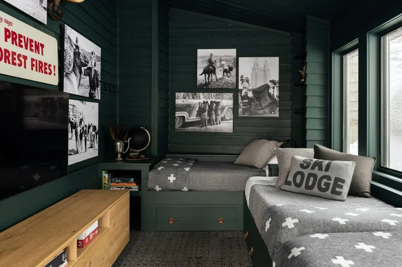 Teal bedroom with black and white photos and grey bedding. 