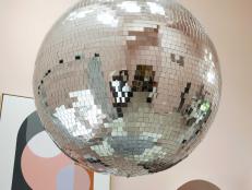 A 40-inch disco ball made from polyfoam with reflective glass mirror tiles makes a big statement above the dining table. The disco ball is extra resistant to cracking, and sure to add a fun party vibe to any get together. “We put it in the corner, so it doesn’t cast a ton of reflection all over the house,” says designer Brian Patrick Flynn. “It gives the space a memorable identity.”