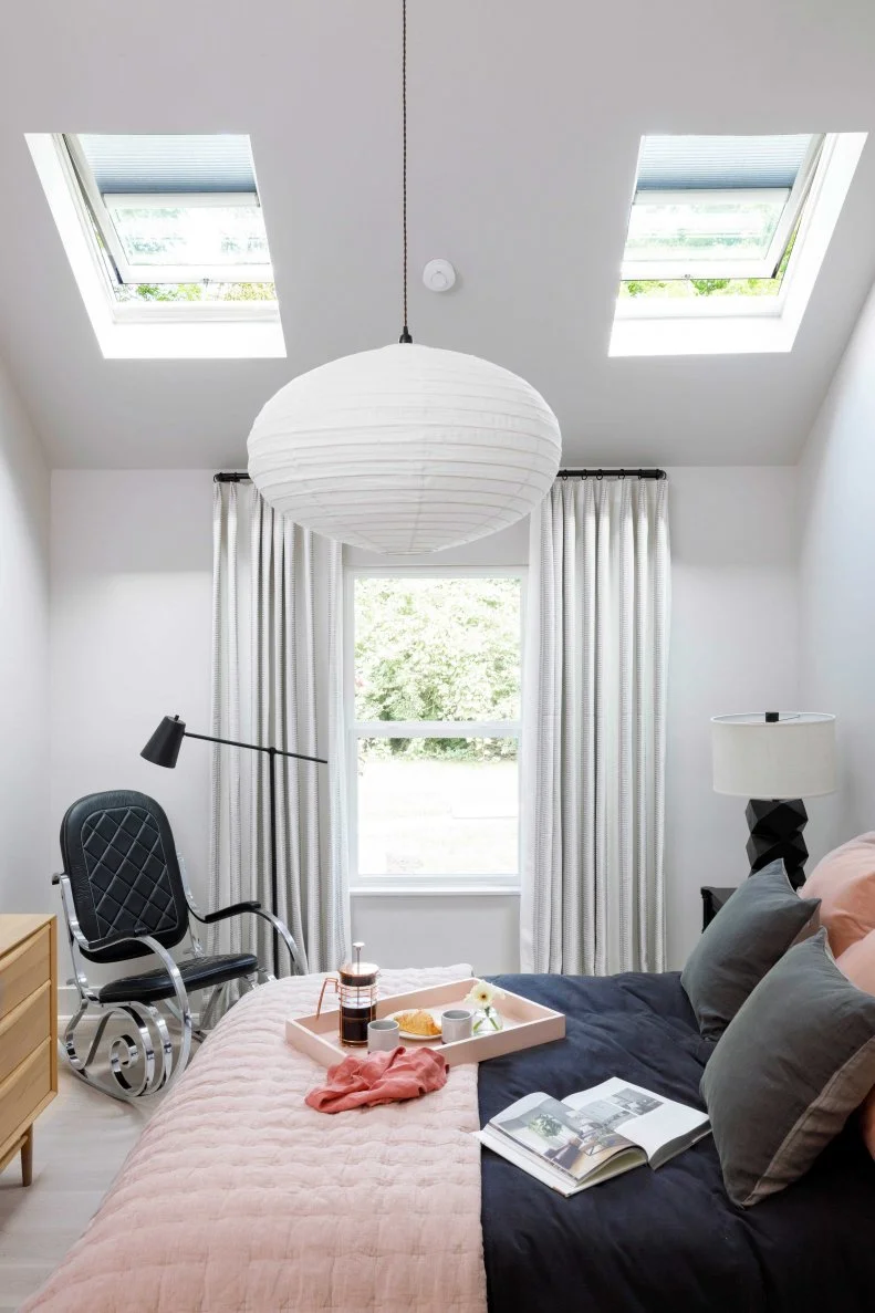 A window with backyard views and innovative solar powered fresh air skylights give this main bedroom a strong connection with the natural beauty located just outside.