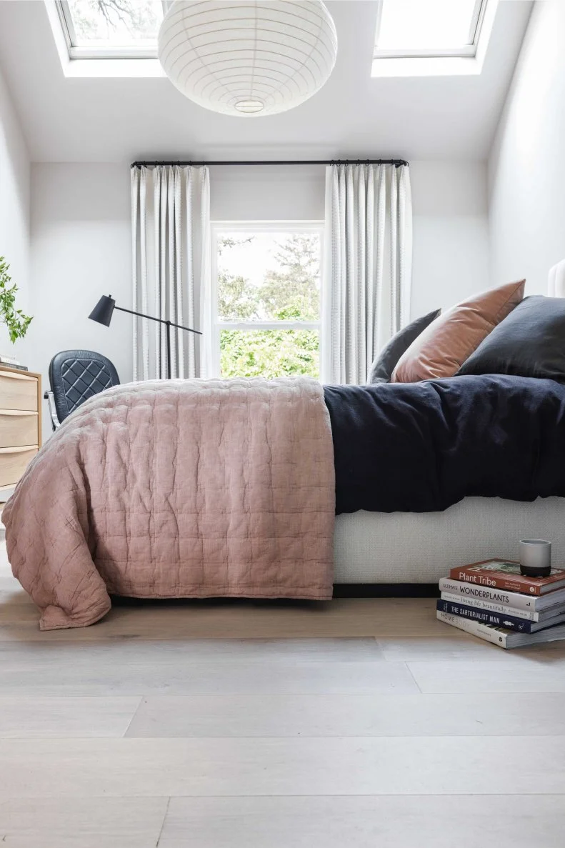 A soft black linen queen duvet cover and mauve-colored linen quilt make the main bedroom’s enticing queen bed extra chic and cozy.