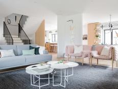 Living room with gray sofa, white coffee tables, and pink armchairs
