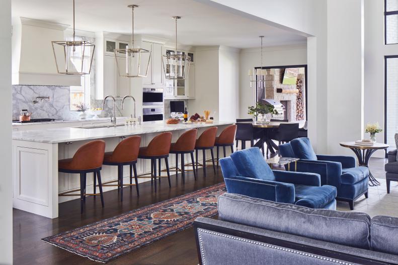 View of an expansive white marble kitchen with leather barstools